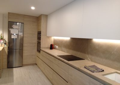 Muebles de cocina con armarios altos blancos a techo y armarios bajos de roble